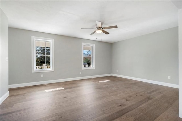 spare room featuring ceiling fan, baseboards, and wood finished floors