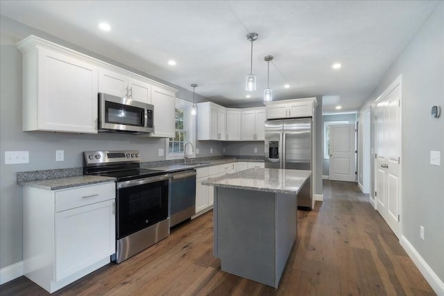 kitchen featuring stainless steel appliances, white cabinetry, a sink, and dark wood-type flooring