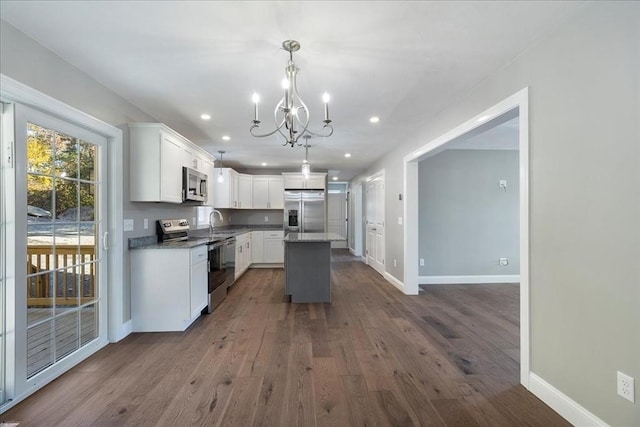 kitchen with baseboards, dark wood finished floors, a kitchen island, appliances with stainless steel finishes, and white cabinetry