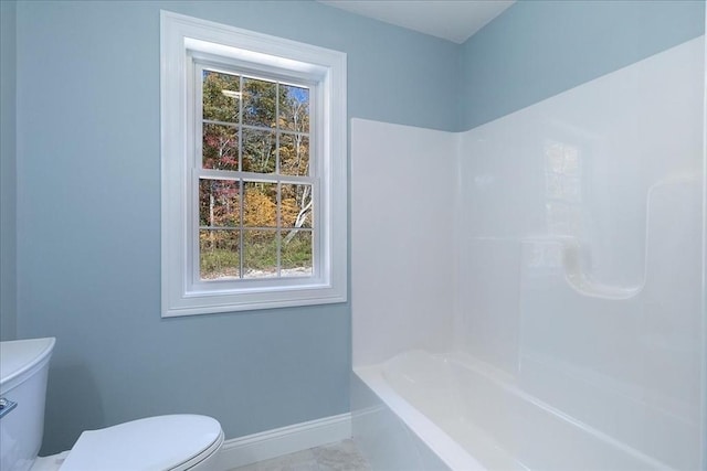 full bathroom featuring baseboards, shower / tub combination, and toilet