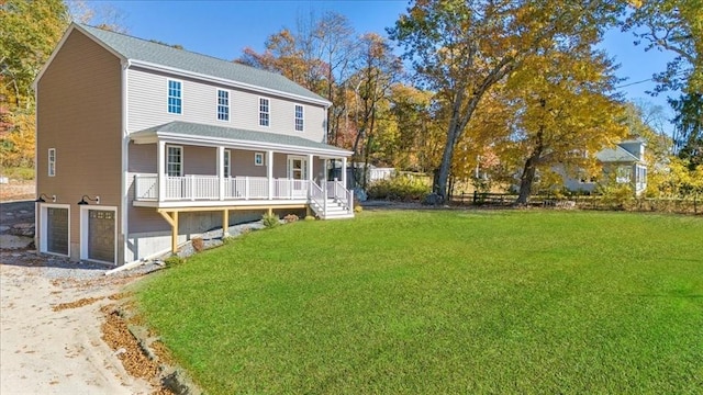 view of front of property featuring a porch, a front yard, driveway, and a garage