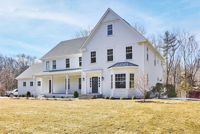 view of front facade with a standing seam roof, metal roof, a front lawn, and a porch