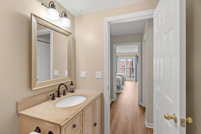 bathroom with vanity, wood finished floors, and baseboards