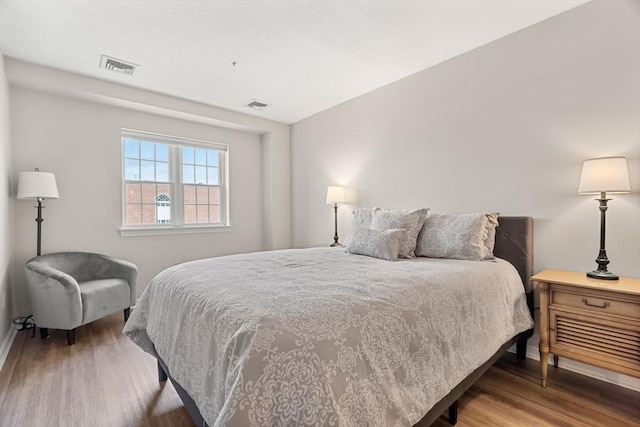 bedroom featuring visible vents and wood finished floors