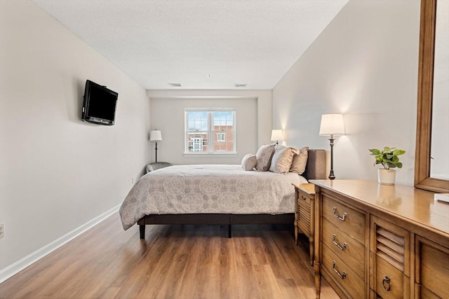 bedroom with visible vents, baseboards, and light wood-style flooring