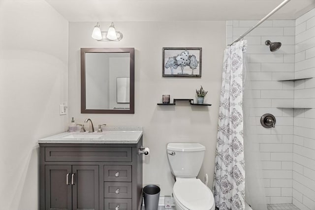 full bathroom featuring vanity, toilet, and a tile shower