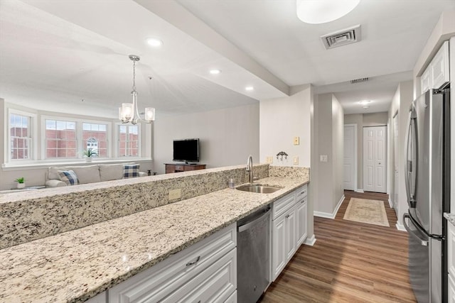 kitchen with wood finished floors, visible vents, a sink, white cabinets, and appliances with stainless steel finishes