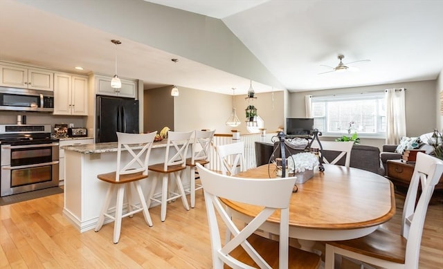 dining room with a ceiling fan, lofted ceiling, recessed lighting, and light wood finished floors