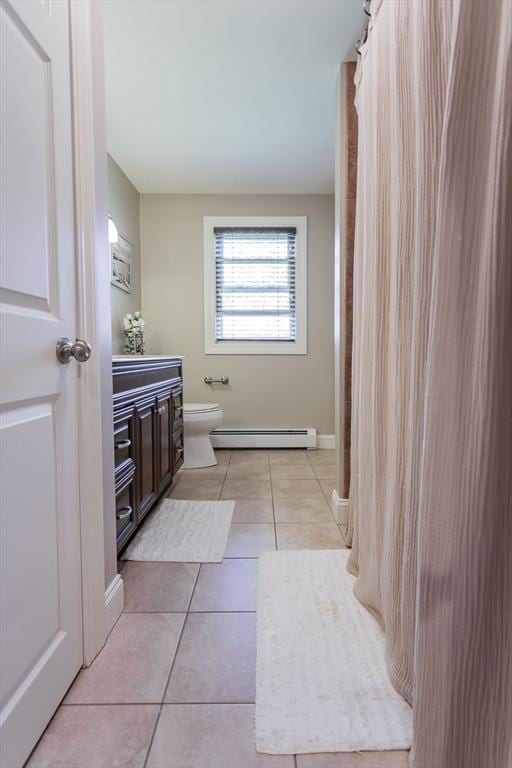 full bathroom with baseboard heating, vanity, toilet, tile patterned floors, and baseboards
