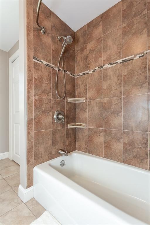 bathroom featuring bathing tub / shower combination and tile patterned flooring