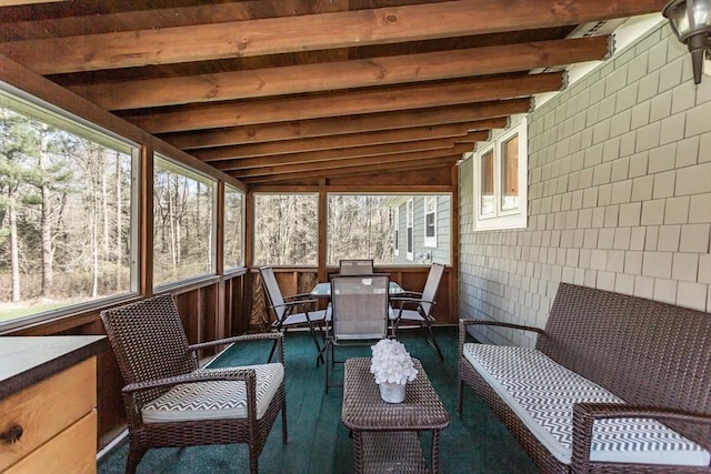 sunroom / solarium with beam ceiling and outdoor dining space