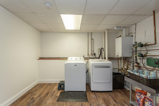 clothes washing area with laundry area, wood finished floors, baseboards, tankless water heater, and separate washer and dryer