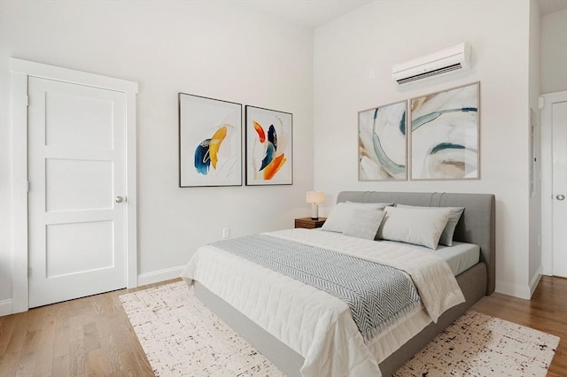 28 Main St Unit 4, Medford, MA 02155 - bedroom with a wall mounted AC, light wood finished floors, and baseboards