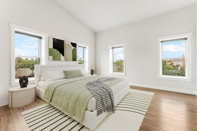 28 Main St Unit 4, Medford, MA 02155 - bedroom with multiple windows, wood finished floors, baseboards, and lofted ceiling