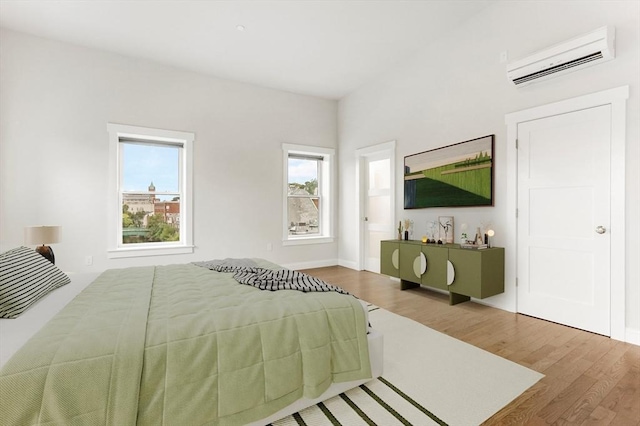28 Main St Unit 4, Medford, MA 02155 - bedroom with an AC wall unit, wood finished floors, and baseboards