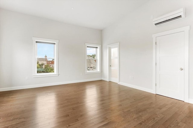 28 Main St Unit 4, Medford, MA 02155 - unfurnished bedroom featuring an AC wall unit, wood finished floors, and baseboards