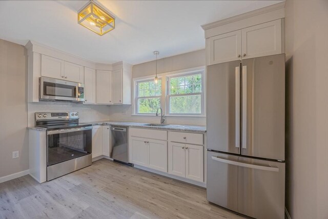 136 E St, South Hadley, MA 01075 - kitchen featuring stainless steel appliances, light wood-style floors, tasteful backsplash, pendant lighting, and white cabinets