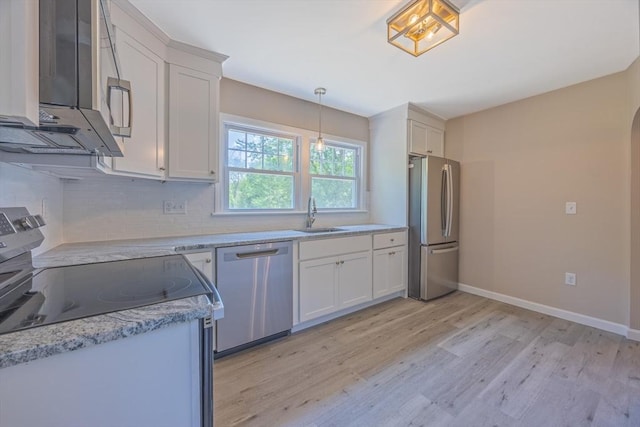 136 E St, South Hadley, MA 01075 - kitchen with appliances with stainless steel finishes, light wood-type flooring, tasteful backsplash, white cabinetry, and decorative light fixtures