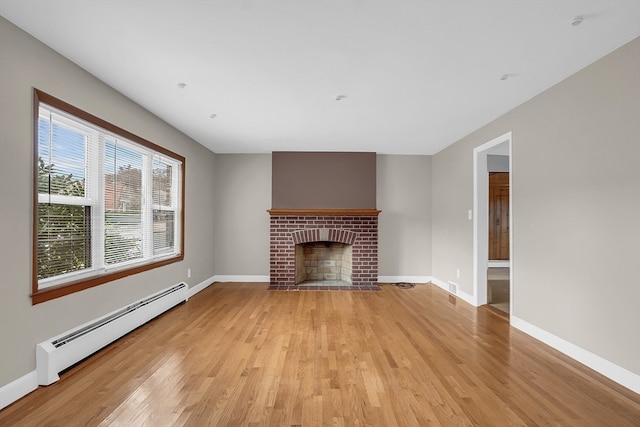 unfurnished living room featuring light hardwood / wood-style flooring, baseboard heating, and a fireplace