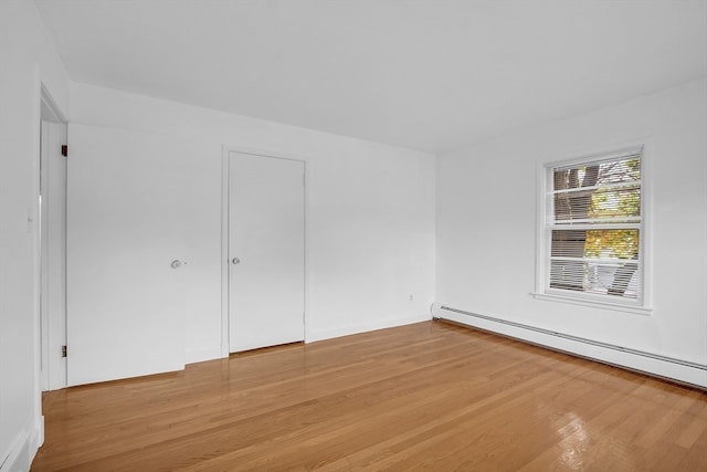 unfurnished room with light hardwood / wood-style flooring and baseboard heating