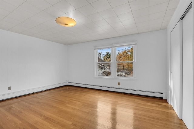 unfurnished room featuring light hardwood / wood-style flooring and baseboard heating