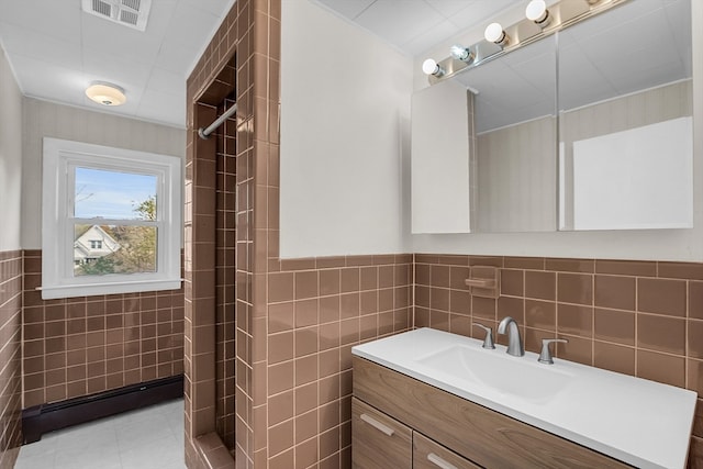 bathroom with vanity, tile patterned floors, tile walls, and walk in shower