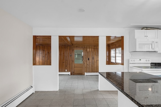 kitchen featuring baseboard heating, wooden walls, white cabinetry, and white appliances