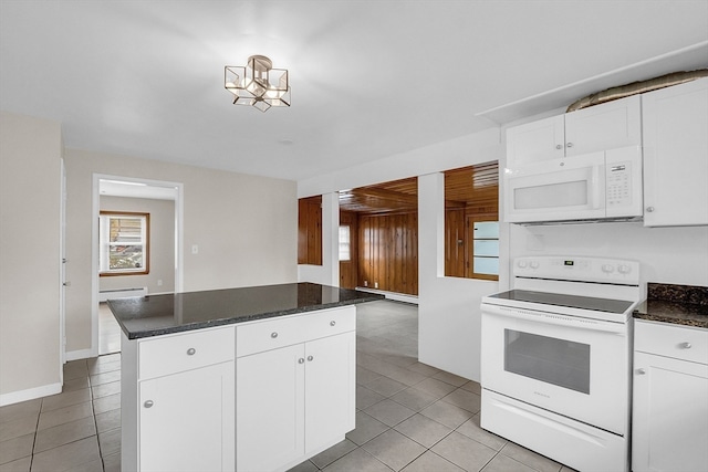 kitchen with white cabinets, light tile patterned floors, and white appliances