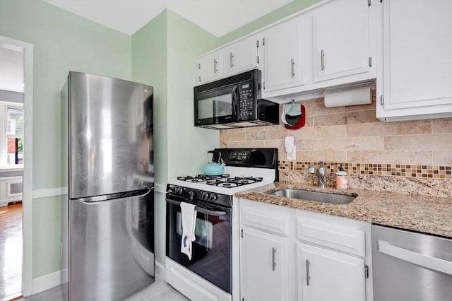 9 Twomey Ct Unit 52, Boston, MA 02127 - kitchen with stainless steel appliances, light stone countertops, white cabinets, and backsplash