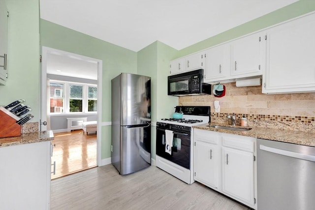 9 Twomey Ct Unit 52, Boston, MA 02127 - kitchen with appliances with stainless steel finishes, light wood-style flooring, white cabinetry, and backsplash