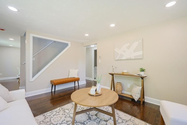 living area featuring wood finished floors, stairs, baseboards, and recessed lighting