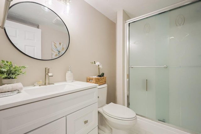bathroom with toilet, a stall shower, and vanity