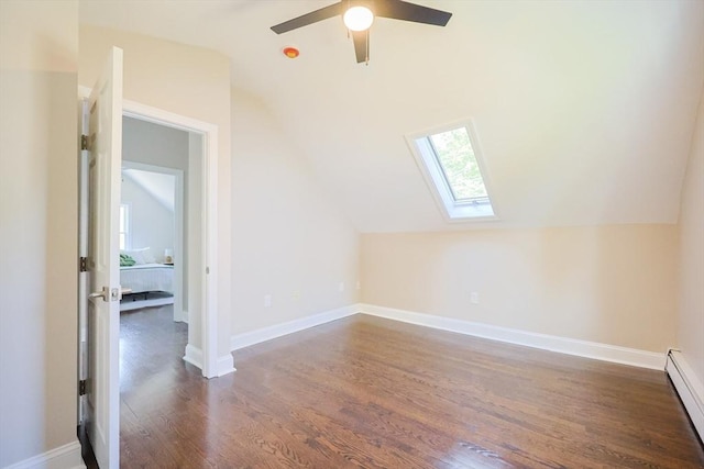 additional living space with a skylight, a baseboard radiator, dark wood-style flooring, vaulted ceiling, and ceiling fan