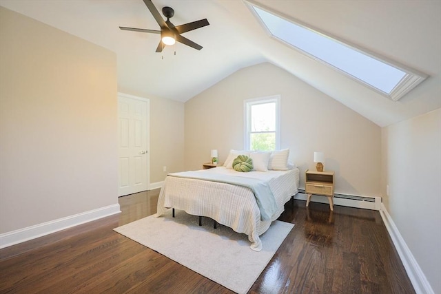 bedroom featuring a skylight, wood finished floors, lofted ceiling, baseboards, and baseboard heating