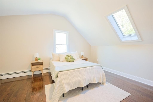 bedroom featuring a skylight, a baseboard heating unit, wood finished floors, vaulted ceiling, and baseboards