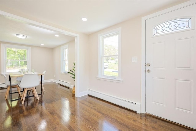 foyer entrance featuring a baseboard heating unit, wood finished floors, healthy amount of natural light, and recessed lighting