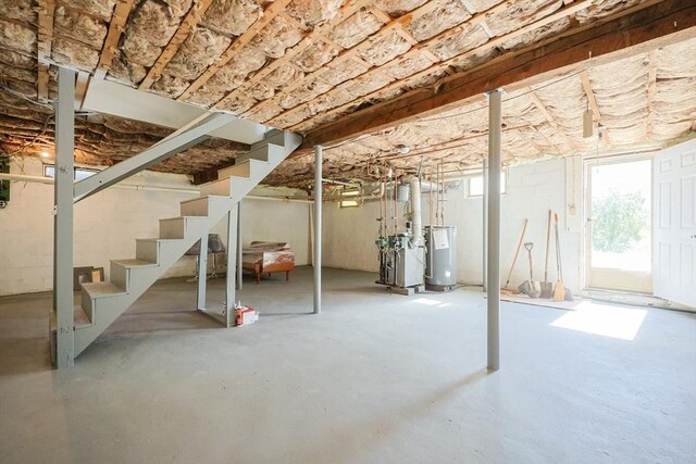basement with stairs, a heating unit, and water heater
