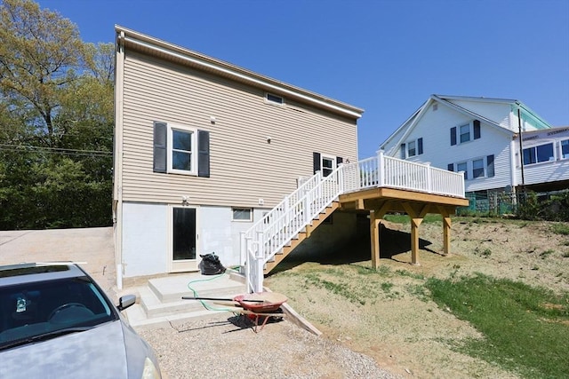 back of house featuring stairs and a wooden deck