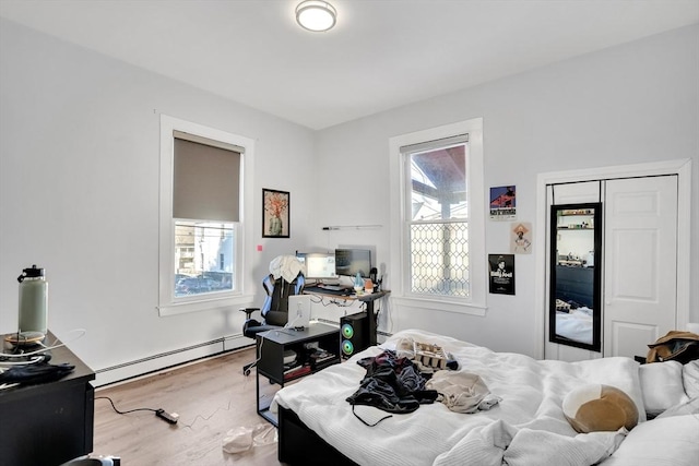 bedroom with hardwood / wood-style flooring and a baseboard radiator