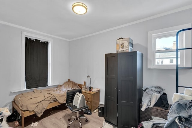 bedroom with crown molding and light hardwood / wood-style floors