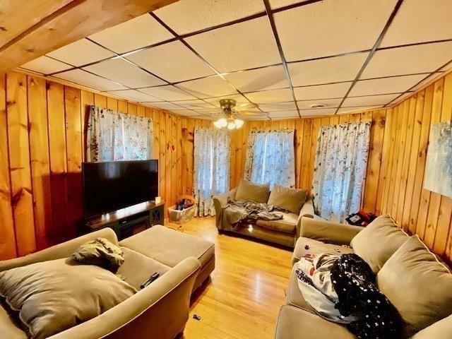 1025 Main St, Worcester, MA 01603 - living area with wooden walls, wood finished floors, and a drop ceiling