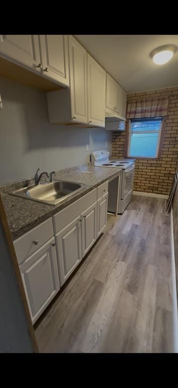 1025 Main St, Worcester, MA 01603 - kitchen with white range with electric cooktop, white cabinetry, light wood-type flooring, and extractor fan