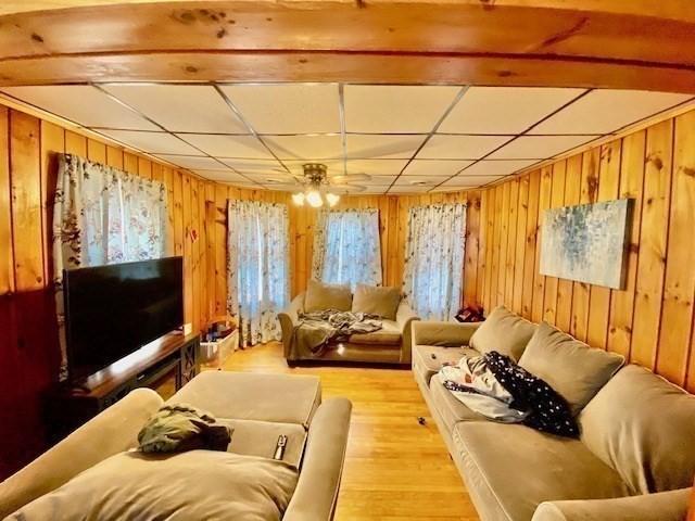 1025 Main St, Worcester, MA 01603 - living room with wood walls, light wood-style floors, and a ceiling fan