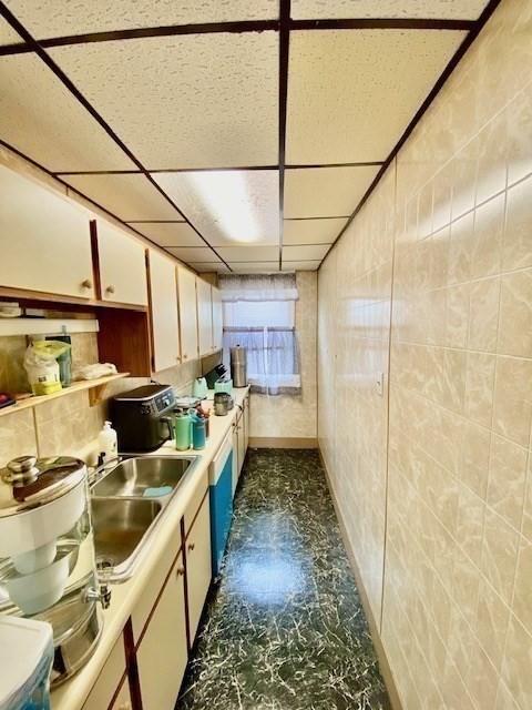 1025 Main St, Worcester, MA 01603 - kitchen featuring white cabinetry, light countertops, and a paneled ceiling