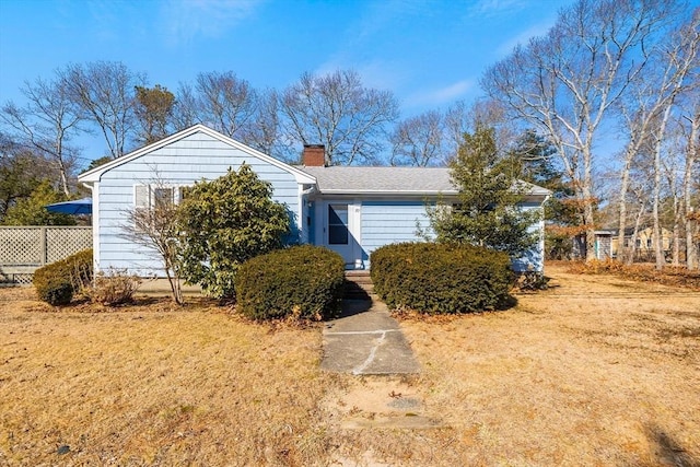 view of front of house with a chimney and fence