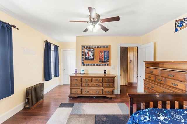 bedroom with ceiling fan, baseboards, radiator heating unit, and dark wood-type flooring