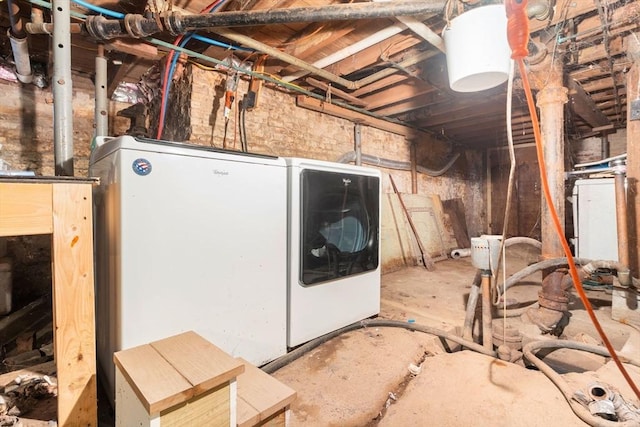 unfinished basement featuring white refrigerator and independent washer and dryer