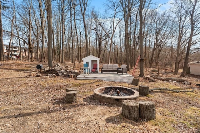 view of yard featuring an outdoor structure, a shed, and an outdoor fire pit