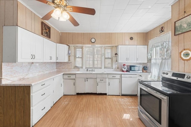 kitchen with open shelves, white cabinetry, stainless steel appliances, wood walls, and light countertops