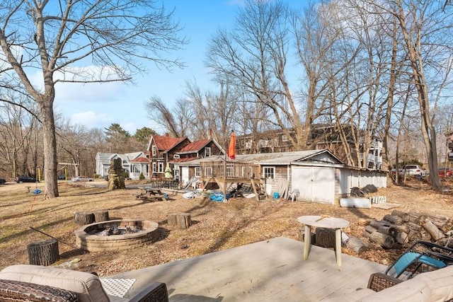 view of yard with a wooden deck, a residential view, an outdoor fire pit, and an outdoor structure